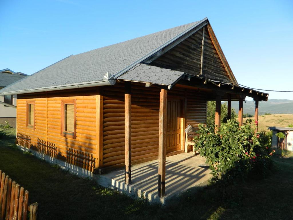 a log cabin with a porch and a roof at Prenoćište Stupovi in Novi Pazar