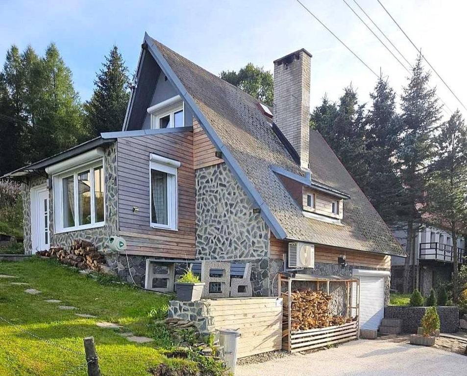 uma casa com um telhado de gambrel em Chalet Maria HOT TUBE SAUNA em Loucná pod Klínovcem