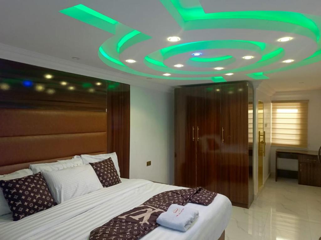 a bedroom with a bed with a green ceiling at Global Signature Hotel and Resort in Ibadan