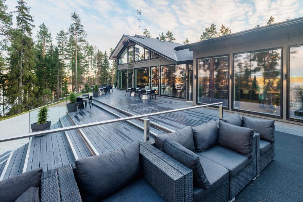 a house with a couch sitting on a deck at Boutique-hotelli Vellamo - Lehmonkärki Resort in Asikkala