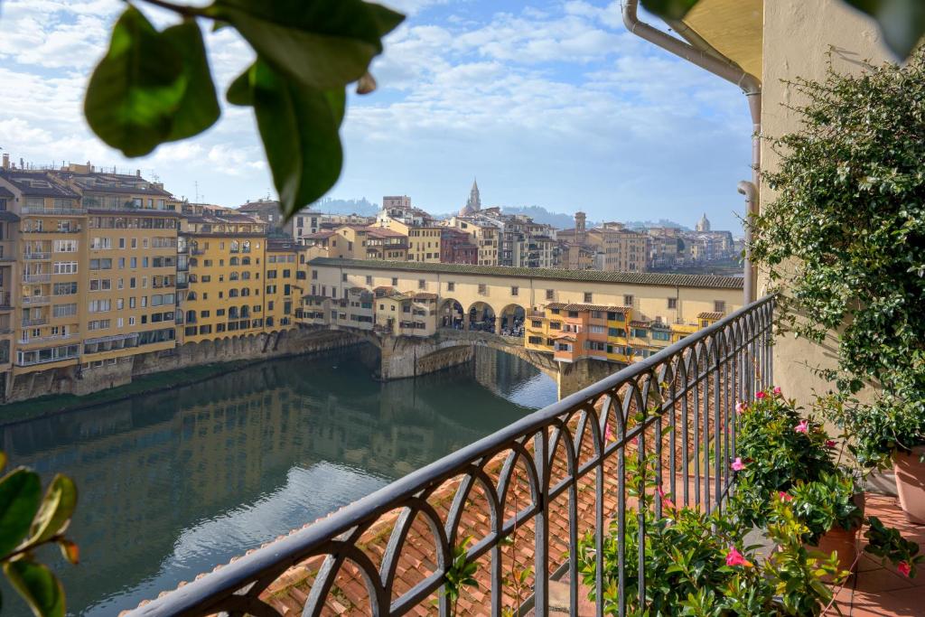einen Balkon mit Blick auf eine Brücke über den Fluss in der Unterkunft Hotel degli Orafi in Florenz