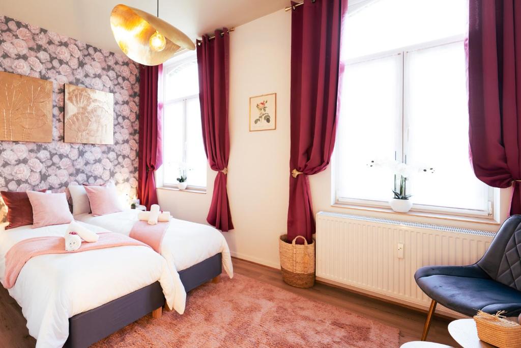 1 dormitorio con 2 camas y 1 silla en Lets Relax - Coté jardin, en Mons