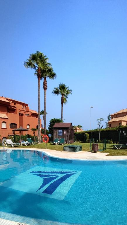 duży basen z palmami w tle w obiekcie Duplex Penthouse in Estepona- Mountain and Sea views w mieście Estepona