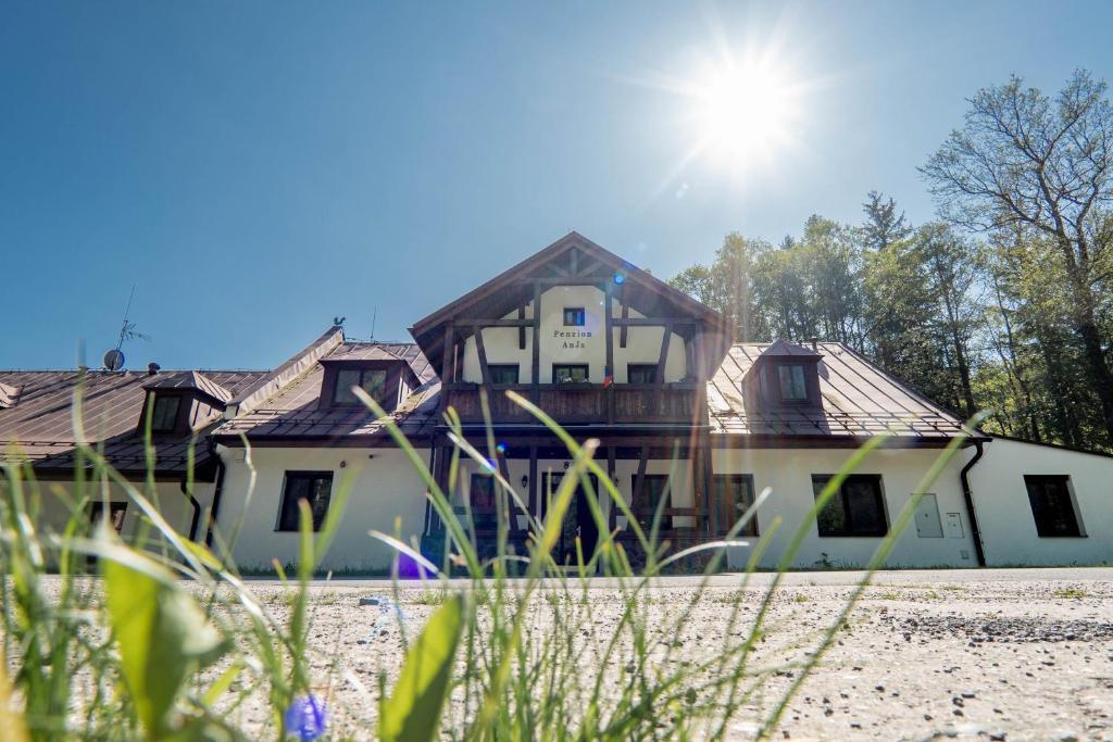 dom ze słońcem na niebie w obiekcie Pension Anja w mieście Andělská Hora