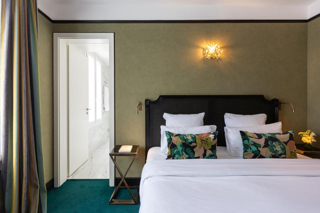 a bedroom with a bed with white sheets and pillows at New Hotel République in Paris