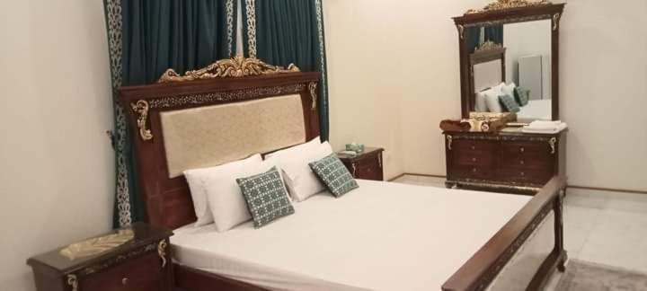 a bedroom with a large bed and a mirror at SeaView Family Guest House Small Bukhari in Karachi
