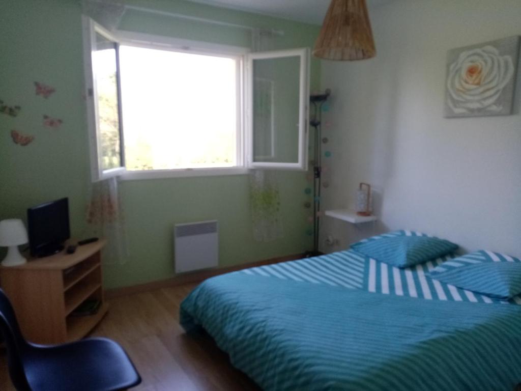 Schlafzimmer mit einem Bett und einem Fenster in der Unterkunft Le chêne blanc in La Genétouze