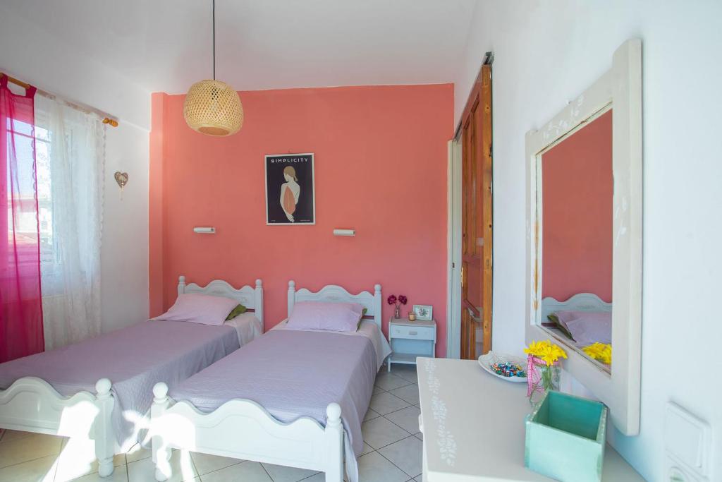 two beds in a room with red walls at A4 - Rosemary Apartment in Nydri