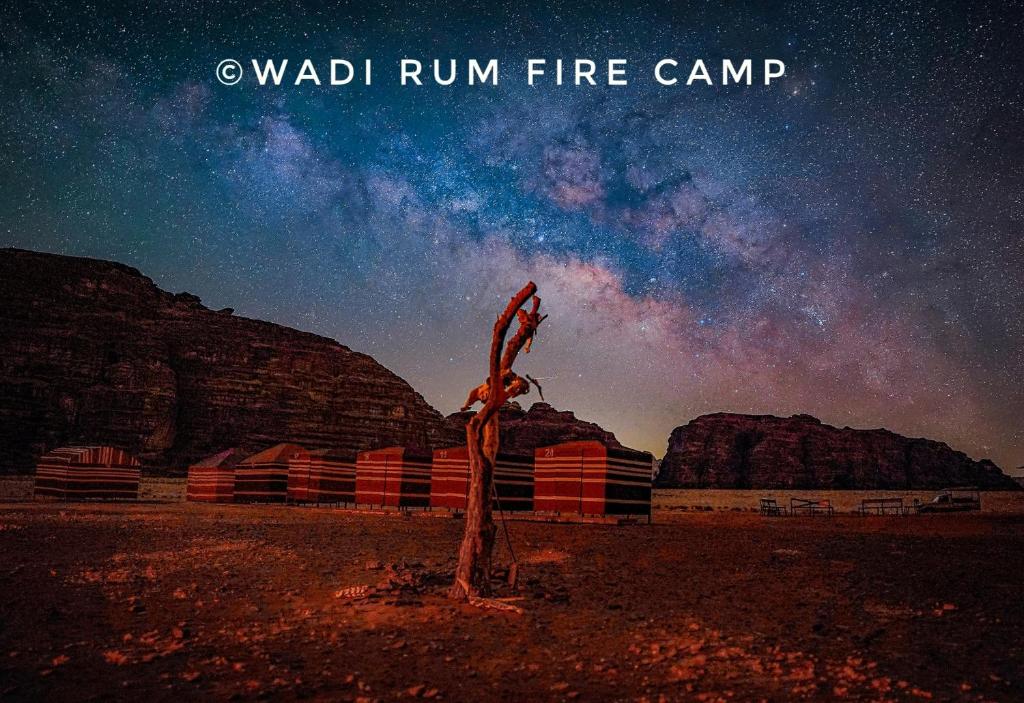 a sign in the middle of a desert under a night sky at Wadi Rum Fire Camp in Wadi Rum