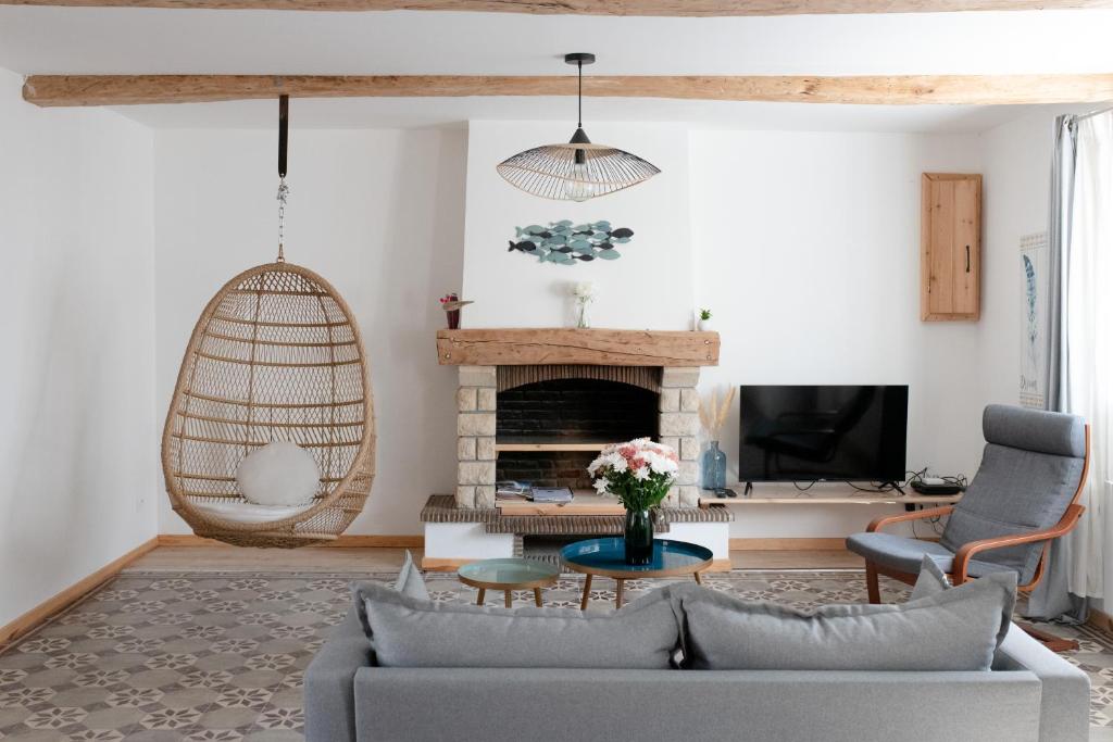 a living room with a couch and a fireplace at Les Frangines - maison de ville avec jardin Ault in Ault