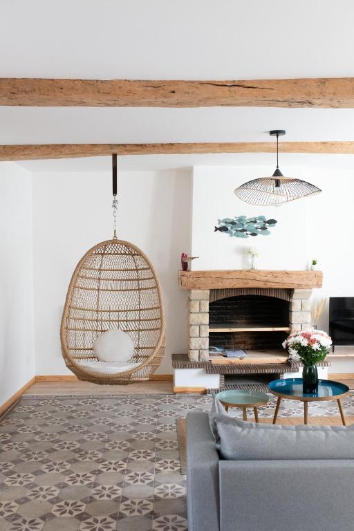 - un salon avec une chaise suspendue en rotin dans l'établissement Les Frangines - maison de ville avec jardin Ault, à Ault