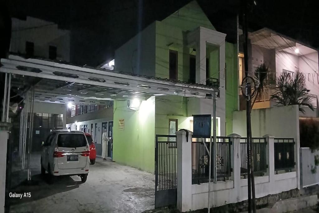 ein Auto, das nachts vor einem Gebäude parkt in der Unterkunft OYO 93861 Adinda Guest House Syariah in Garut