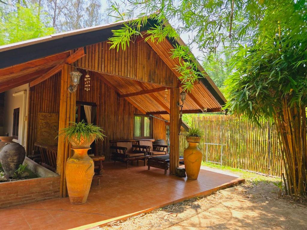 einem Pavillon mit zwei großen Orangenvasen auf einer Terrasse in der Unterkunft Kaengkrachan Boathouse Paradise Resort in Kaeng Kachan