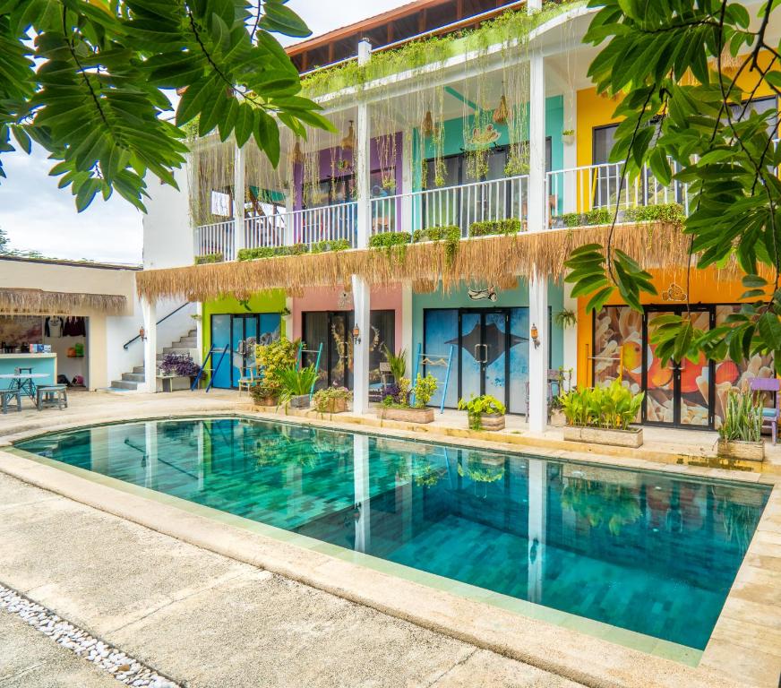 a swimming pool in front of a building at Dragon Dive Komodo Dive Resort in Labuan Bajo