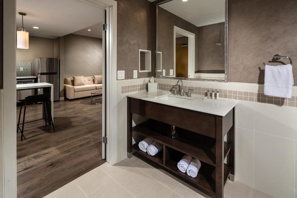 a bathroom with a sink and a living room at Hotel Aventura in Los Angeles