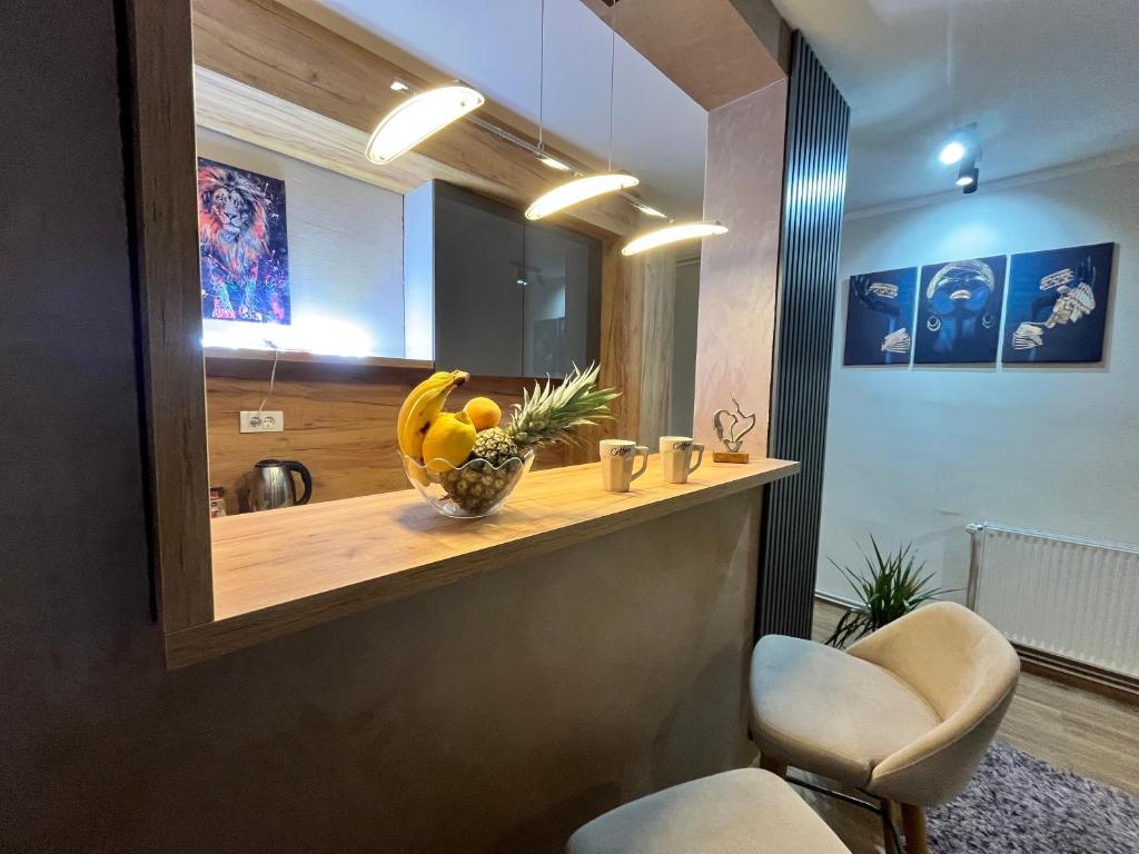 a kitchen with a counter with a bowl of fruit on it at Apartman Irma sweet in Sarajevo