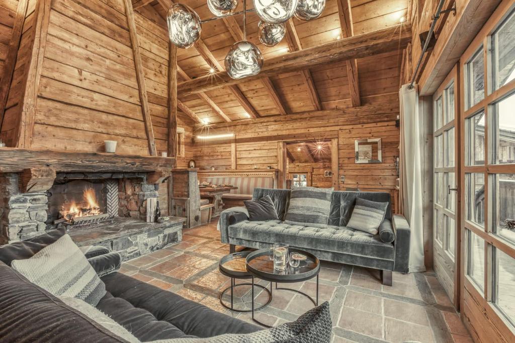 un salon avec des canapés et une cheminée dans l'établissement Chalet Edelweiss, à Megève