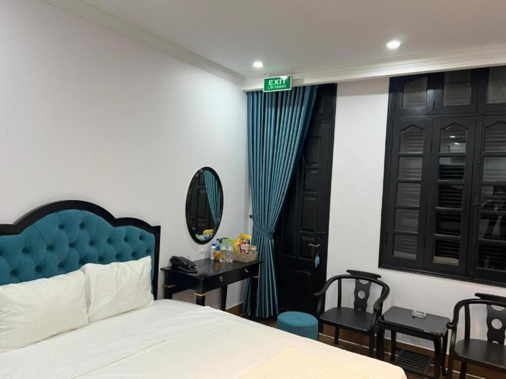 ハノイにあるNhật Tân Hotelのベッドルーム(ベッド1台、テーブル、鏡付)
