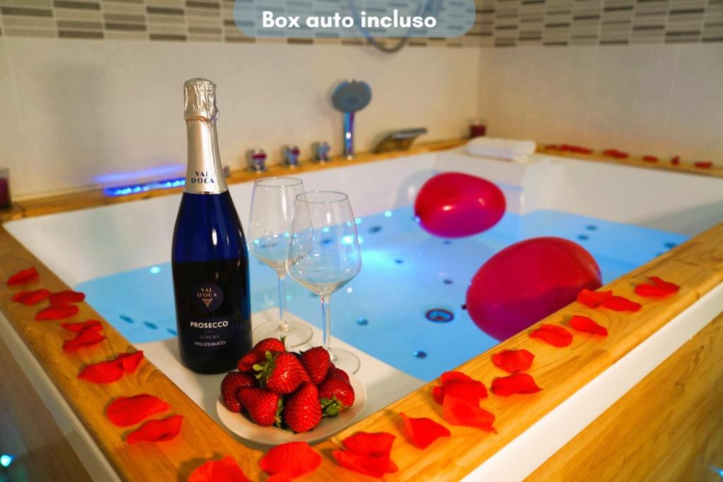 - une bouteille de vin et un bol de fraises dans la baignoire dans l'établissement Suite Votano 24 - RELAX nel CUORE ANTICO di CEGLIE, à Ceglie Messapica