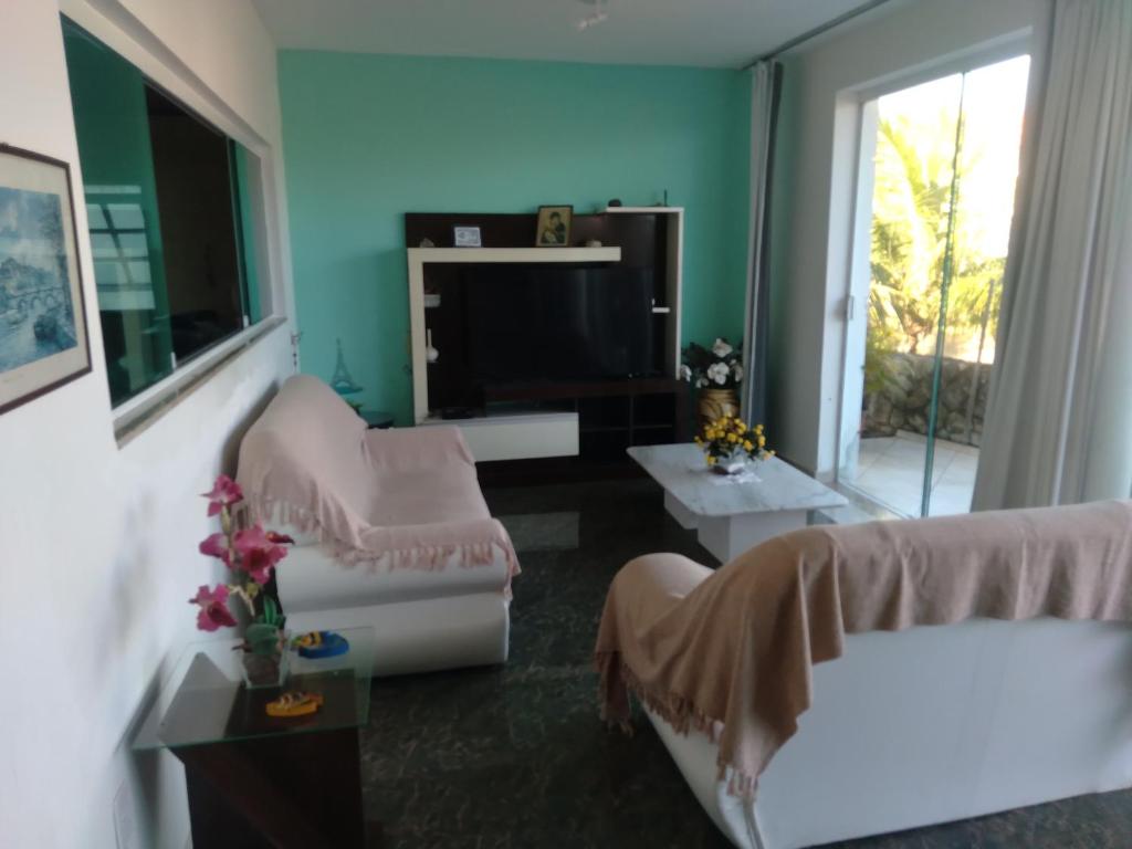 uma sala de estar com um sofá e uma televisão em Confortável, 1min da praia a pé em Niterói