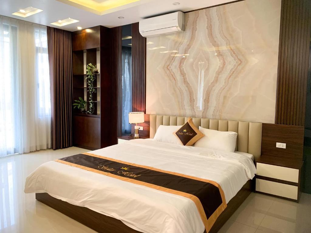 sypialnia z dużym łóżkiem i obrazem na ścianie w obiekcie Solar Hotel w Ha Long