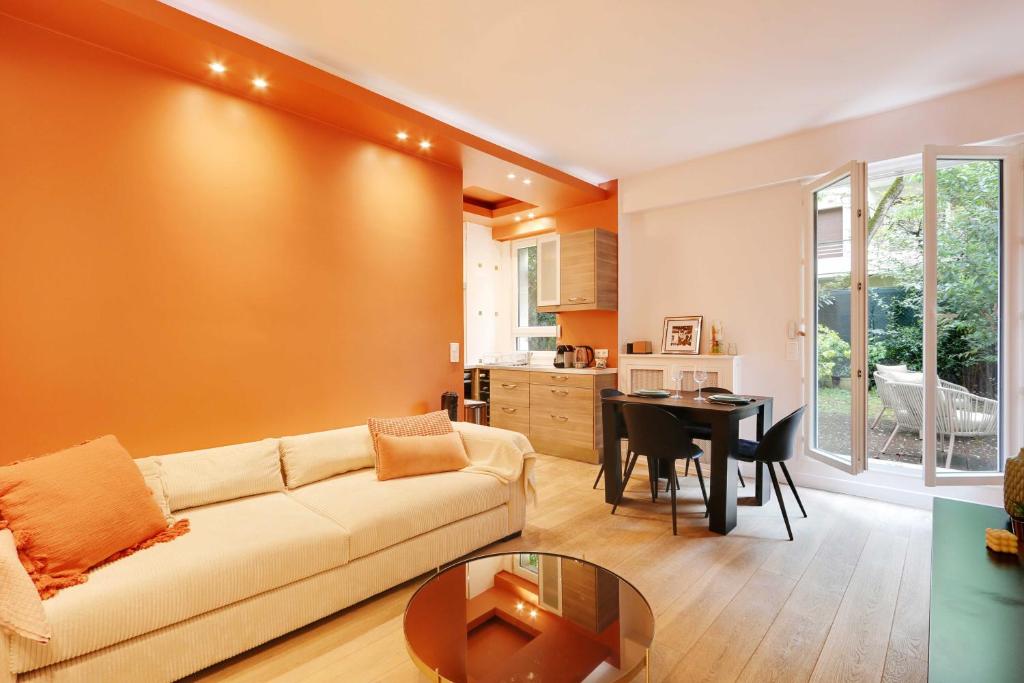 ein Wohnzimmer mit einem Sofa und einem Tisch in der Unterkunft Cosy flat with garden -Neuilly-sur-Seine in Neuilly-sur-Seine
