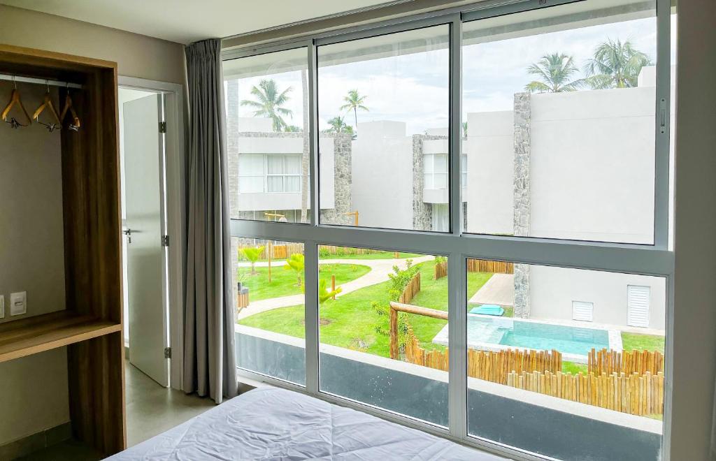 - une chambre dotée d'une grande fenêtre offrant une vue sur la piscine dans l'établissement Casa Marceneiro Milagres, à São Miguel dos Milagres