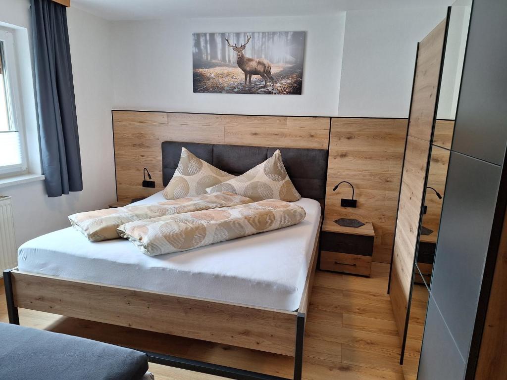 Dormitorio con cama con ciervo en la pared en Haus Waldfriede, en Sankt Leonhard im Pitztal