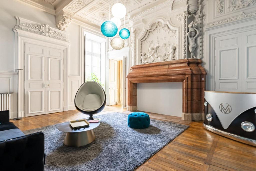 - un salon avec une chaise et une cheminée dans l'établissement Chambellan des Ducs - caractère et central, à Dijon