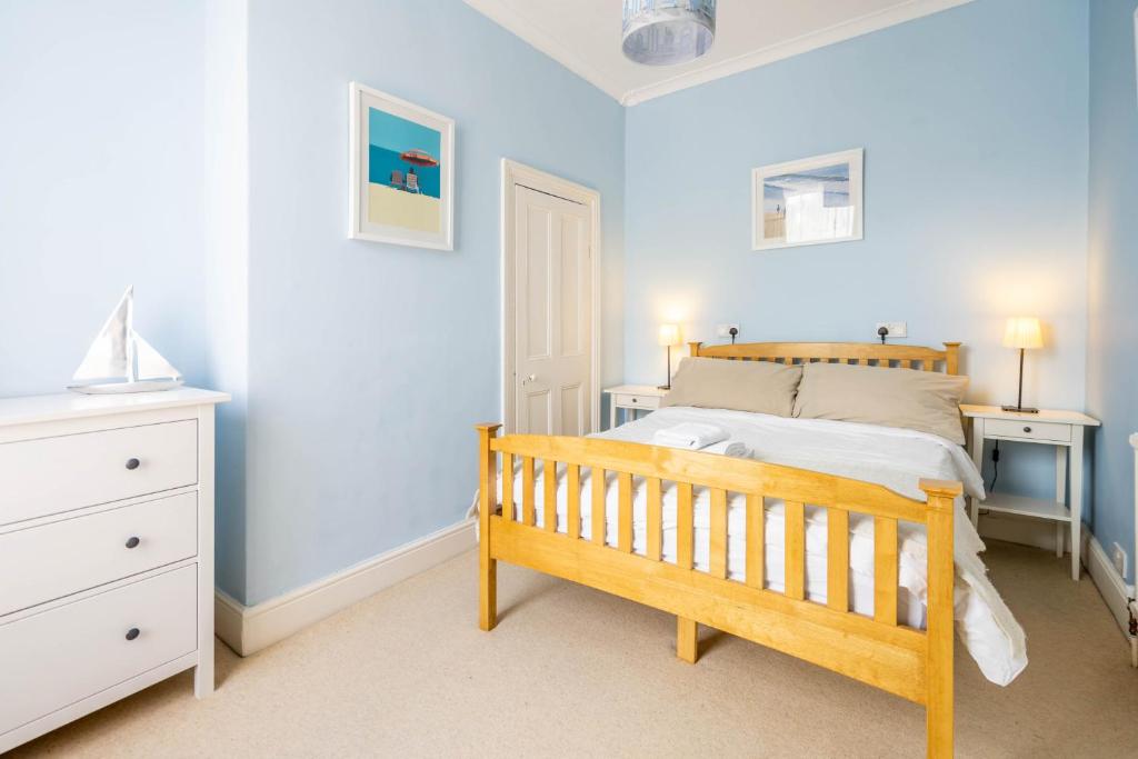 a bedroom with blue walls and a bed with a wooden crib at 3 Claremont Terrace in York