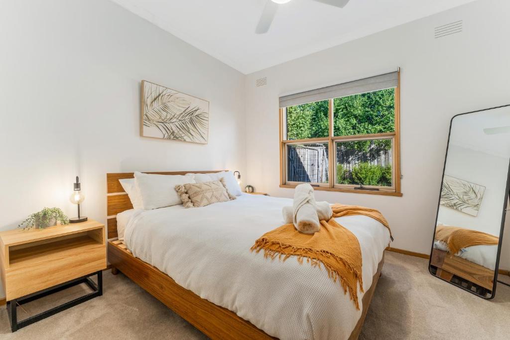 a bedroom with a large bed and a window at Cozy Newtown 2 bedroom unit in Geelong