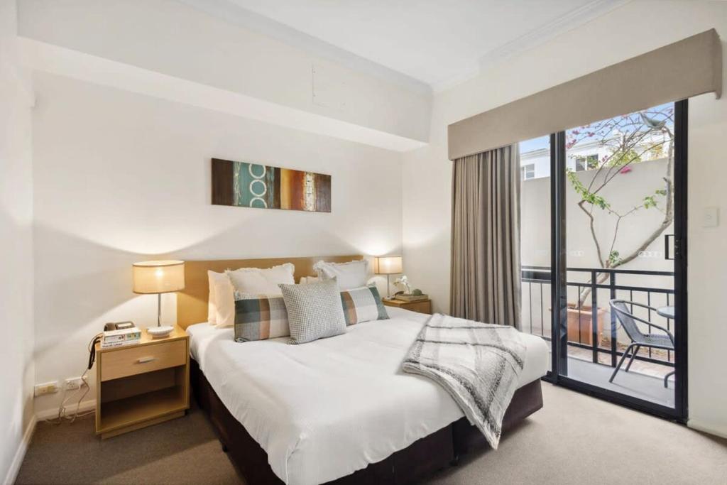 a bedroom with a large bed and a balcony at Perth Premium 1 Bedroom in Perth