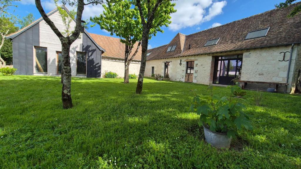 an old house with trees in the yard at Les Granges de l'Épan in Joué-lès-Tours