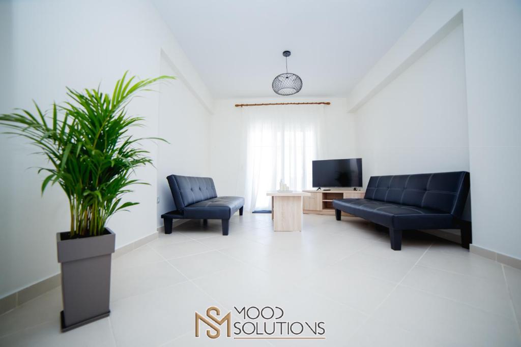 a living room with two couches and a tv at Polys Polychrono MoodSolutions Living in Polykhrono