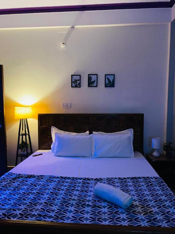 um quarto com uma cama grande e um cobertor azul em Renade Leisure Stay em Agartala