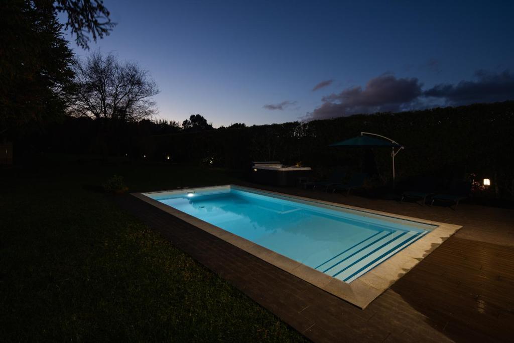 ein Schwimmbad in einem Garten in der Nacht in der Unterkunft Quinta do Ferreiro in Ponta Delgada