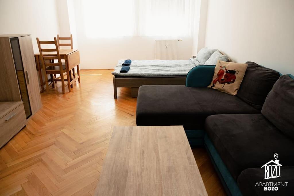 uma sala de estar com um sofá e uma mesa em Otthonos társasházi lakás a Váci út mellett em Budapeste