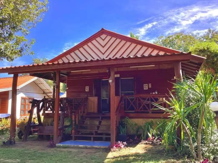 une petite maison avec une terrasse couverte et une terrasse dans l'établissement เชียงคานเรือนไม้ รีสอร์ท, à Amphoe Chiang Khan