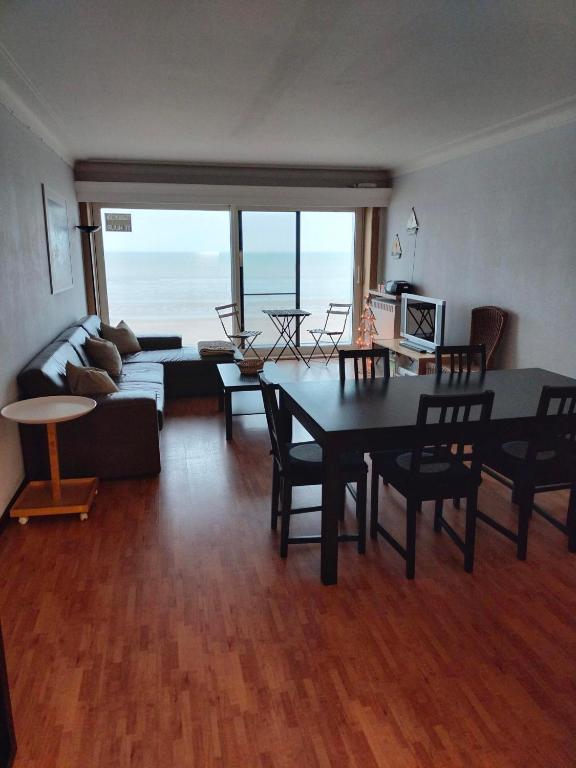 a living room with a table and a couch at Appartement voor gezin in Middelkerke