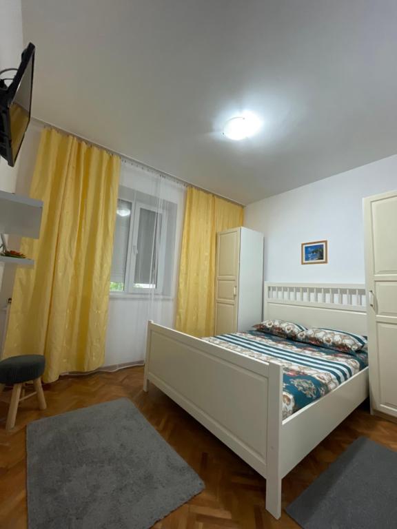 - une chambre avec un lit et un rideau jaune dans l&#39;établissement Apartament Nich, à Mangalia