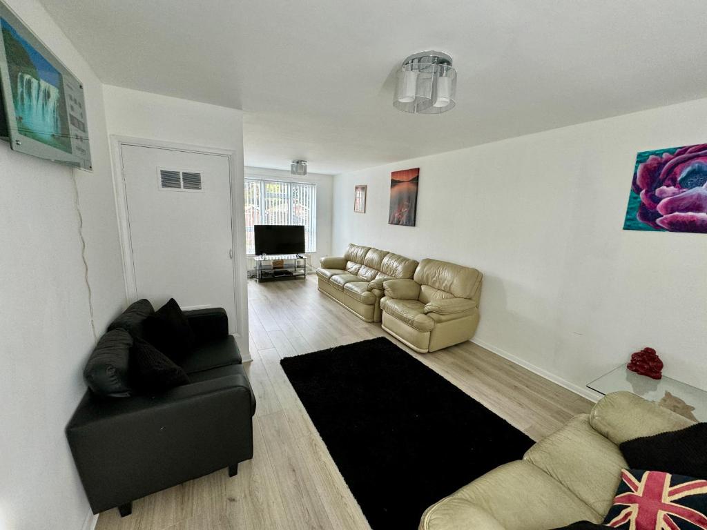 Sala de estar con 2 sofás y TV en Cozy Home, en Twickenham