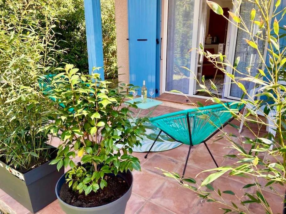 une terrasse avec une chaise verte et des plantes dans l'établissement Eucalyptus Villa 29, à Argelès-sur-Mer