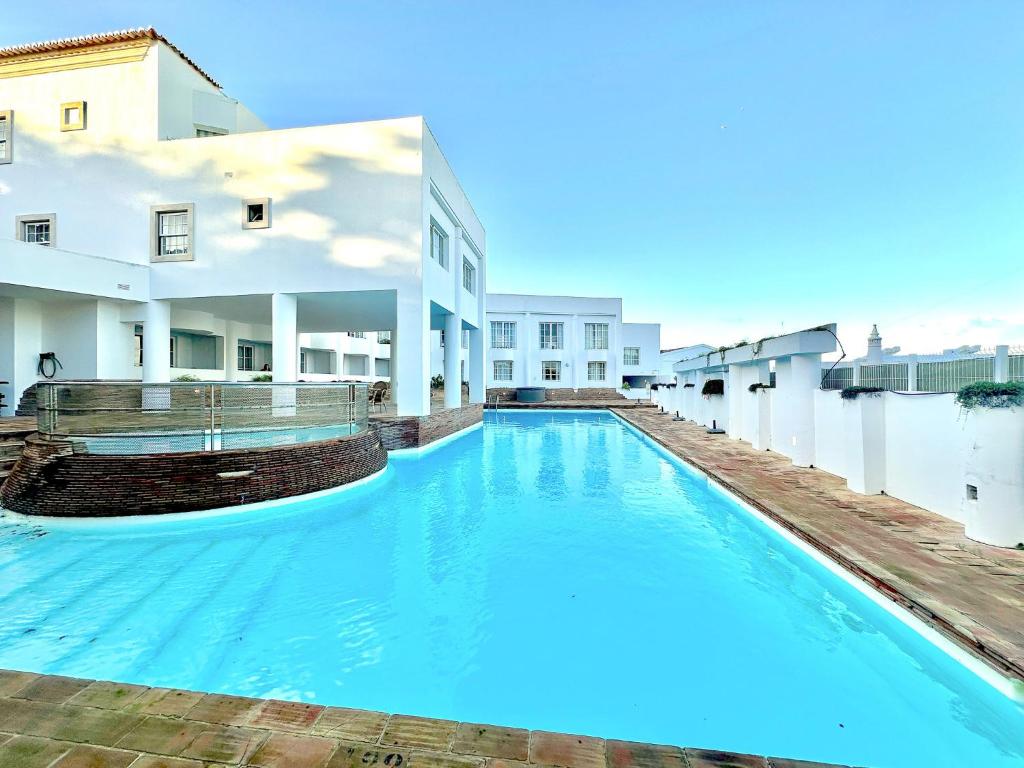 uma grande piscina azul em frente a um edifício em Porta da Vila 408 T1 em Lagos