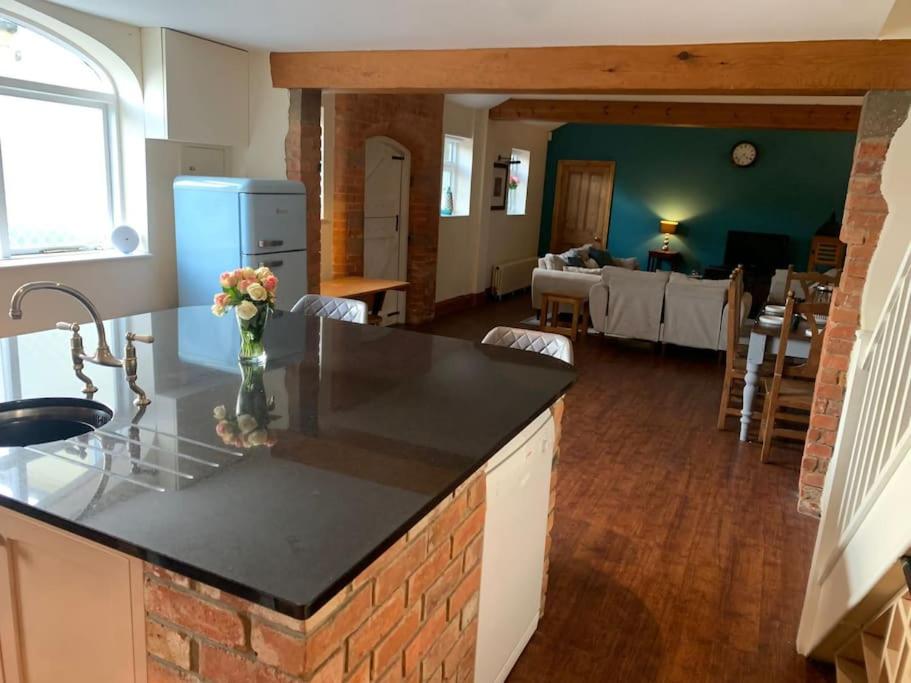 eine Küche mit einer Arbeitsplatte und ein Wohnzimmer in der Unterkunft NEW! The Stables, quiet and central in Bingham