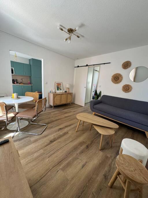 a living room with a blue couch and a table at Appartement centre historique in Narbonne