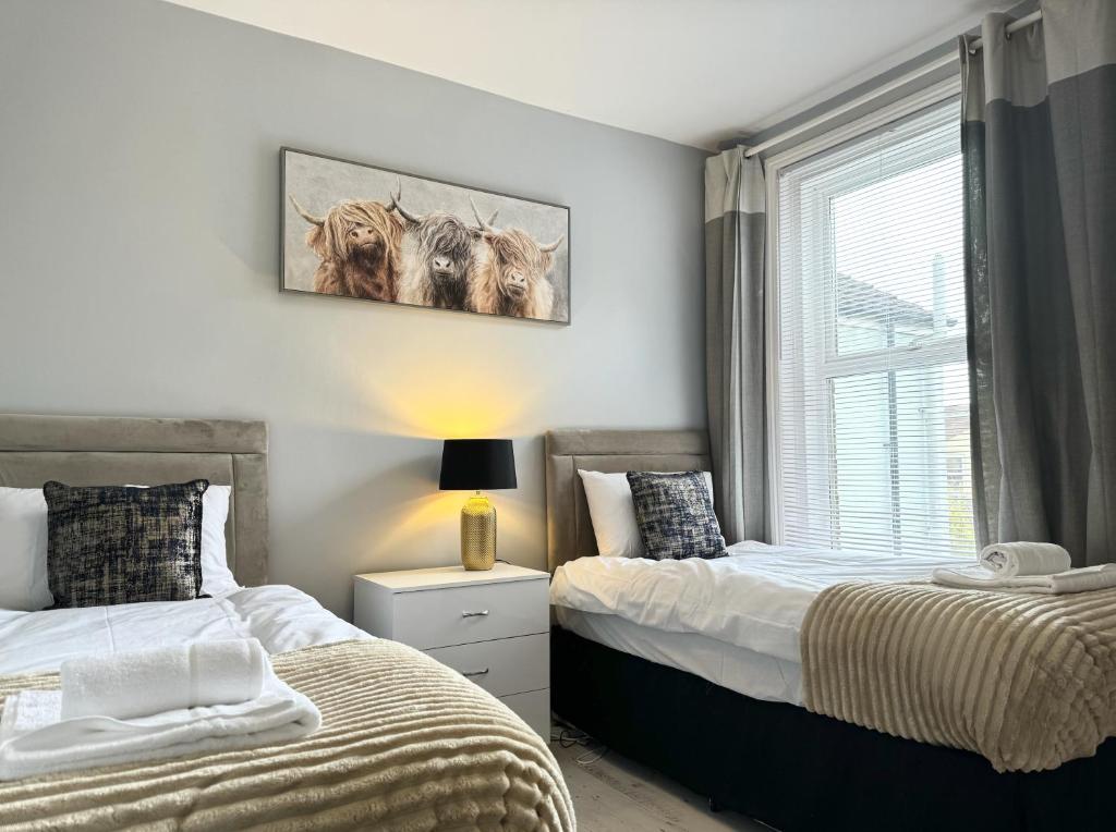 een slaapkamer met 2 bedden en een raam bij BEST PRICE! - Newly Refurbished - Seaside Terrace House- 7 Guests in Portsmouth