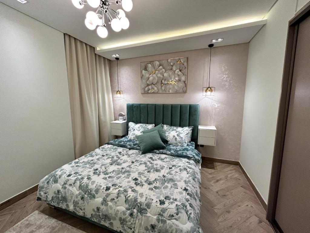 Schlafzimmer mit einem Bett mit einem grünen Kopfteil in der Unterkunft Luxury Romantic Sea View Apartment. in Manama
