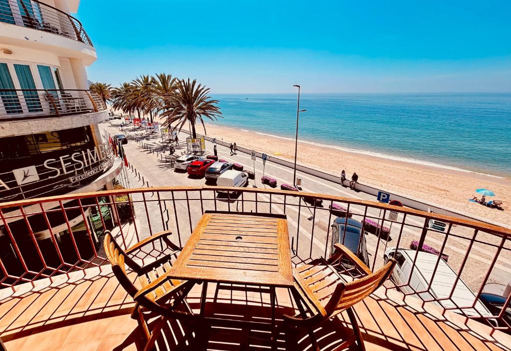 uma mesa e cadeiras numa varanda junto à praia em Vista Azul em Sesimbra