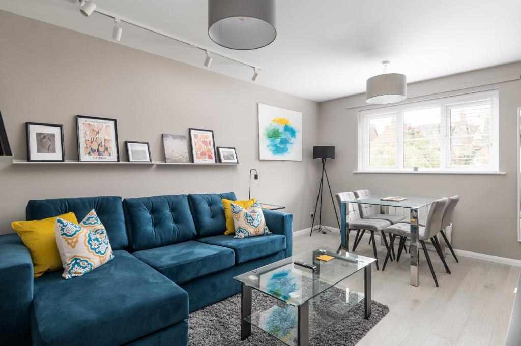 a living room with a blue couch and a table at City Stay Apartments - Geldonia Court Bedford in Bedford