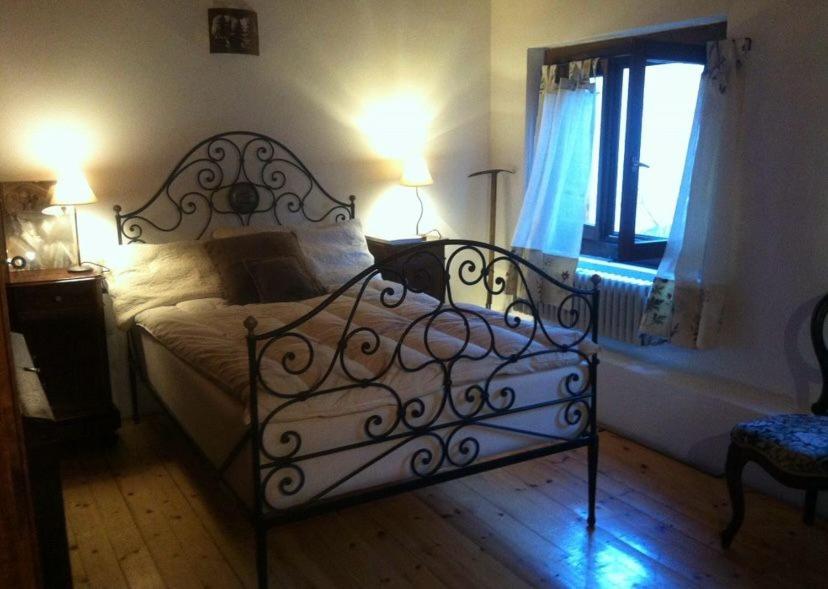 a bed in a bedroom with two lamps and a window at Lago di Como - home holiday in Zelbio